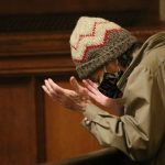 Man in knit hat praying in University Church