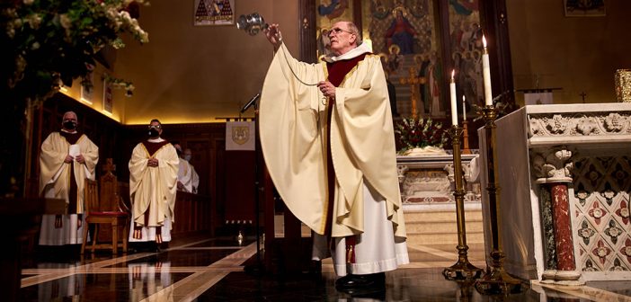 Father McSahne swings a senser on the altar.