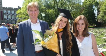 A grad and her family with flowers