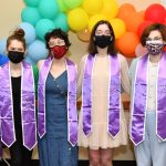 Students posing in front of rainbow balloons at LGBTQ Lavender Graduation with lavender stoles