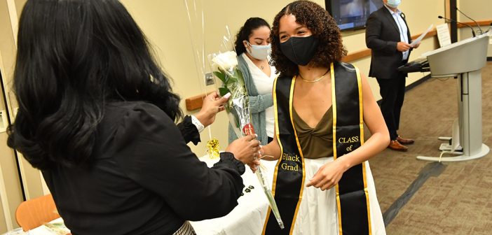 Studnet receiving rose at Black graduation celebration