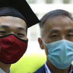 Graduate and his father in masks