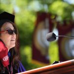 Dean Donna Rapaccioli in purple robes at podium