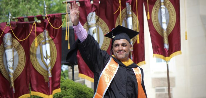 A graduate waving.