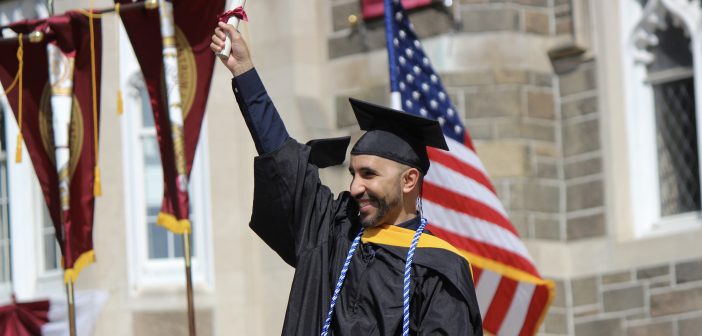A graduate holding up a diploma.