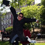 A graduate leaps into the air on Edwards Parade