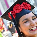 close up of a woman graduate with flowers on her cap