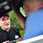 Father McShane talking to man in car