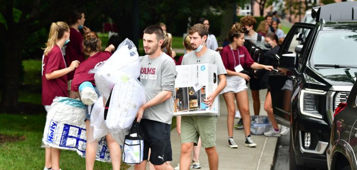 Male students carrying boxes