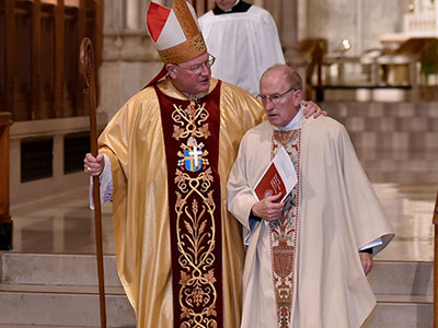 Cardinal Dolan and Father McShane on the altar at St. Patrick's Cathedral during a Mass on October 1, 2016, in honor of the 175th anniversary of Fordham's founding by John Hughes, the first archbishop of New York. Photo by Dana Maxson