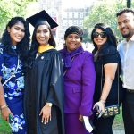A graduate poses with her family for a picture