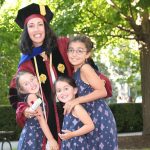 Woman graduate smiling with three children