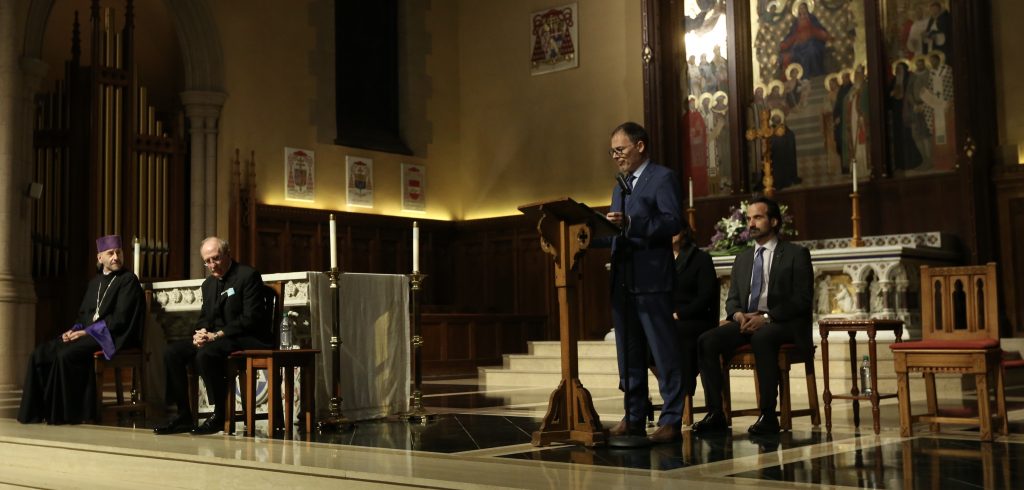 A man stands and speaks in a church setting.