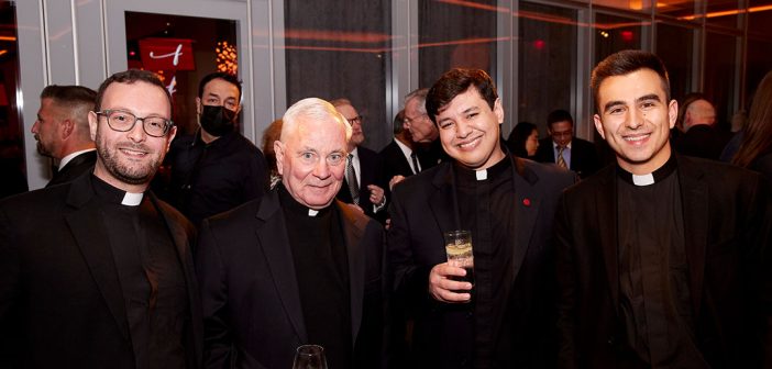 Four men in clerical collars posing at cocktail hour