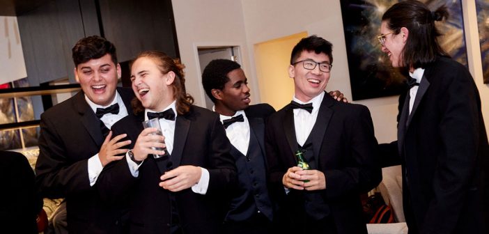 Young men in tuxes laughing