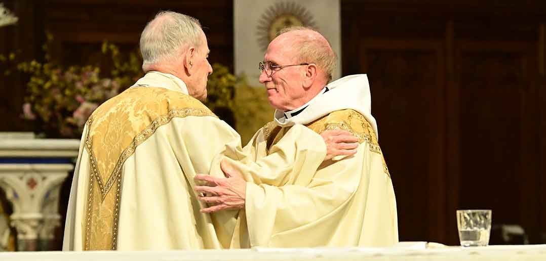 Father McShane embraces Monsignor Thomas J. Shelley,