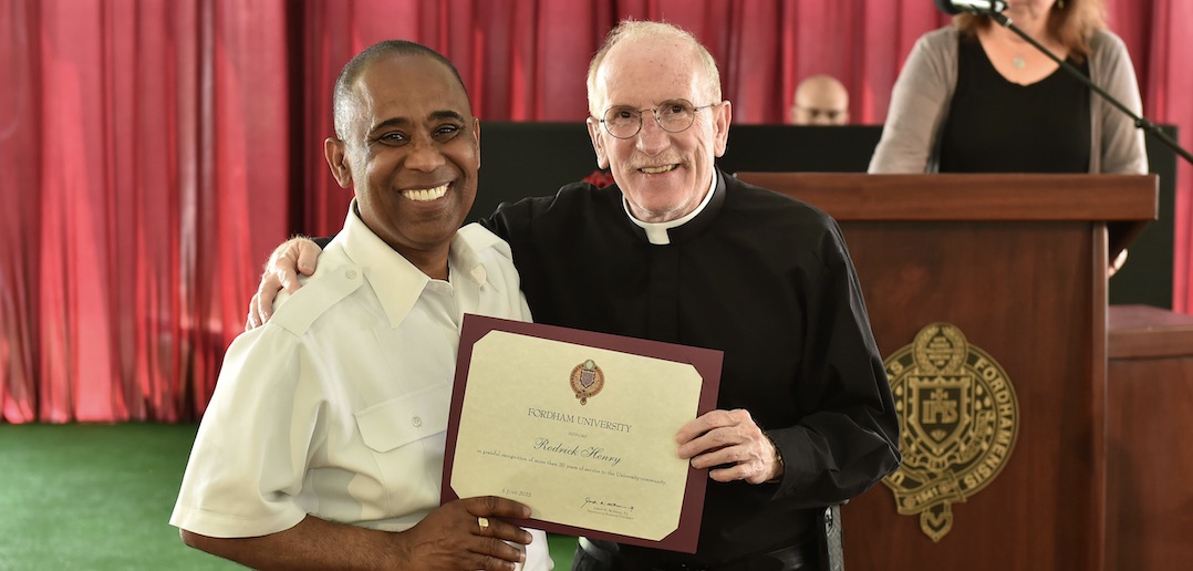 Two men bright smile while holding a certificate.