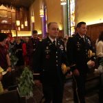 Two men in military uniforms process in University Church