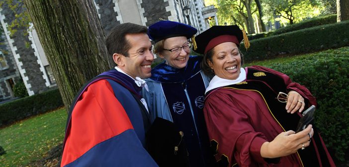 Three people in academic robes taking selfie