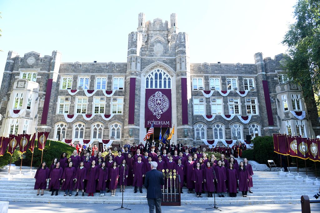 Student choir members stand on Keating Steps