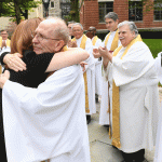 President Tetlow hugging Father McShane