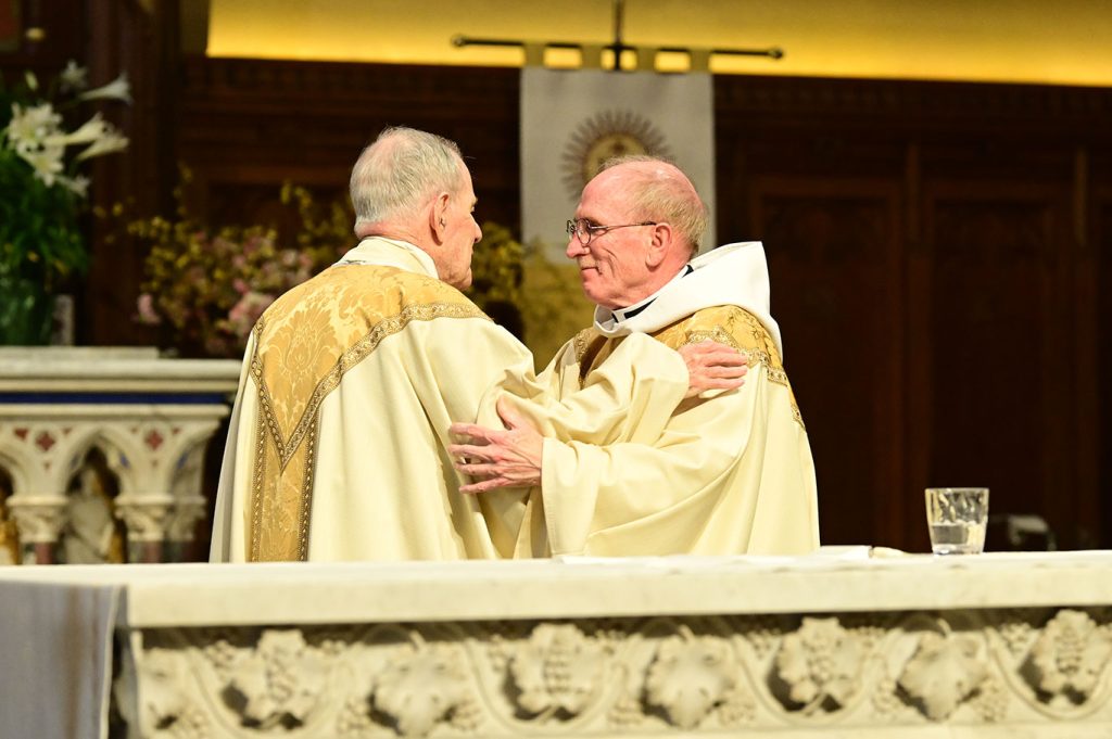 Monsignor Shelley and Father McSahne embracing
