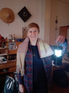 A woman standing in her office holding up a latern