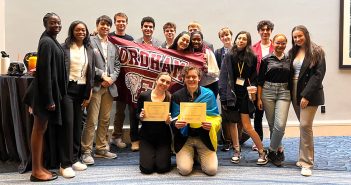 Students standing together with a Fordham banner