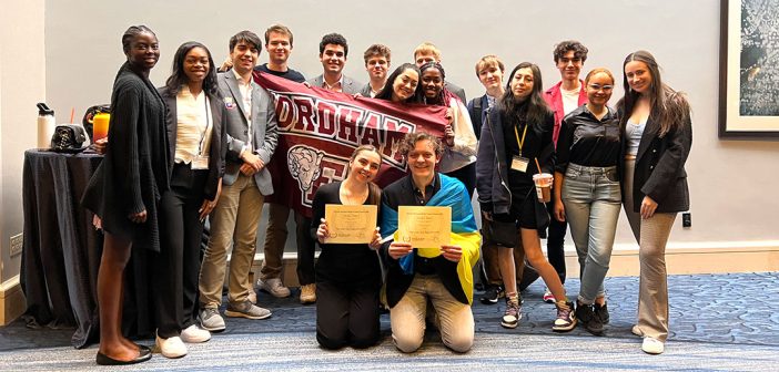 Students standing together with a Fordham banner