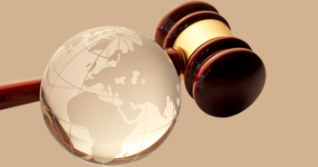 Gavel and clear globe next to each other.