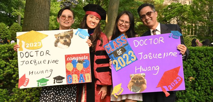 A GSE graduate with family members holding signs