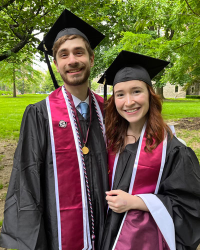 Two college graduates pose for a photo