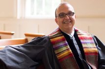 A pastor in his robes sitting in church