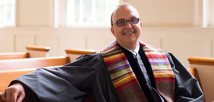 A pastor in his robes sitting in church