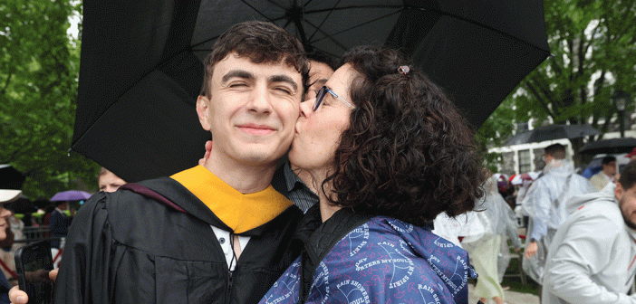 Mom kissing man graduate