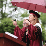 President Tetlow at Commencement podium, pointing at crowd