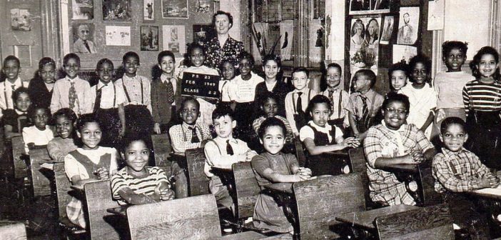 A black and white image of a group of children sitting in a classroom in the Bronx