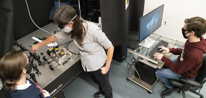 Professor Elizabeth Thrall and students assembling a single-molecule fluorescence microscopemic