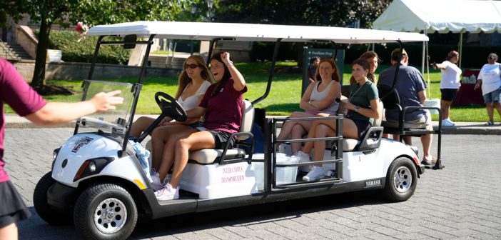 A girl drives a golf cart with passengers.