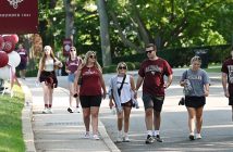 People wearing Fordham T-shirts and walking on the Rose Hill campus during Homecoming weekend in 2022