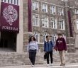Three Fordham students walk in front of Keating Hall.