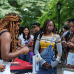 Group of female presenting students at club fair.