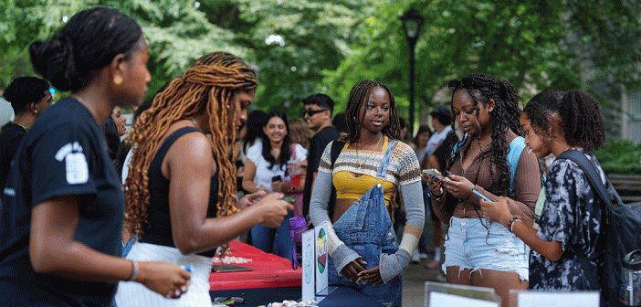 Group of female presenting students at club fair.