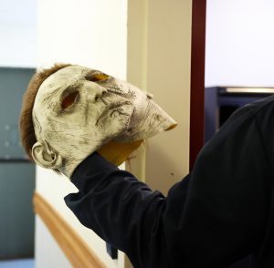 A guy holding a Michael Myers mask 
