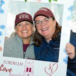 Two people posing inside of a "Fordham Love" frame cutout.