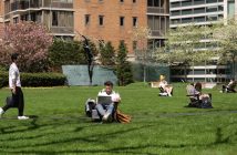 Students study in chairs and walk around the grassy plaza at the Lincoln Center campus.