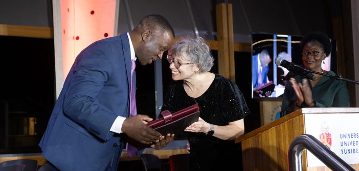 A woman handing an award to a man at a podium.