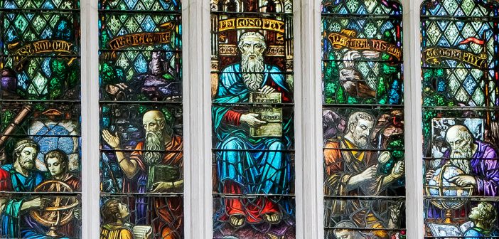 Stained glass depicting several figures in robes representing areas of study such as philosophy