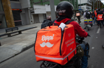 Man driving on bike with orange Rappi bag