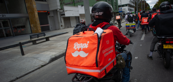 Man driving on bike with orange Rappi bag